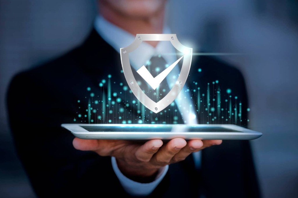 Digital security shield with a checkmark projected from a tablet